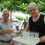 Ingo Wilke (rechts) verteilt an heißen Tagen Wasser in der Bahnhofstraße. Wer durstig ist, wie Bakri Nabin, bekommt einen Becher. Foto: Becker & Bredel.