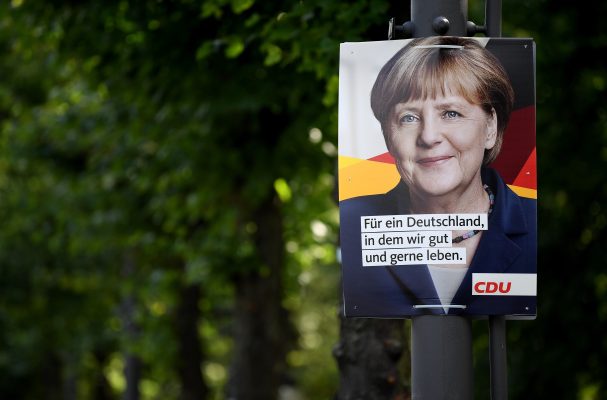 Angela Merkel (CDU) lacht von einem Wahlplakat herunter. Foto:  Foto: Britta Pedersen/dpa.