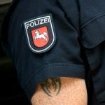 Am Oberarm eines Polizisten ist ein Tattoo erkennbar. Foto: Holger Hollemann/dpa-Bildfunk