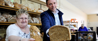 Tobias Hans halft am Montag bei der Tafel in Burbach aus. Im Bild: (l.) Renate Haachs und Ministerpräsident Tobias Hans verteilen Brot. Foto: BeckerBredel