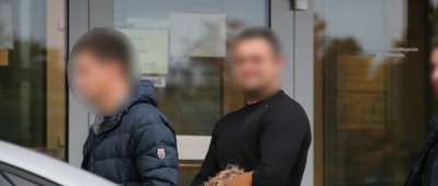 Einer der beiden Beschuldigten (Mitte) wird in Saarbrücken dem Haftrichter vorgeführt. In Begleitung (links sowie rechts): Zivilbeamte. Foto: Brandon Lee Posse