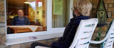 Über Balkone und offene Fenster kann Kontakt zu Bewohnern von Altenheimen gepflegt werden. Foto: Bernd Thissen/dpa-Bildfunk