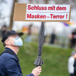 "Schluss mit dem Masken-Terror!" steht auf dem Schild eines Teilnehmers einer Demonstration der Initiative "Querdenken". Foto: dpa-Bildfunk/Christoph Schmidt